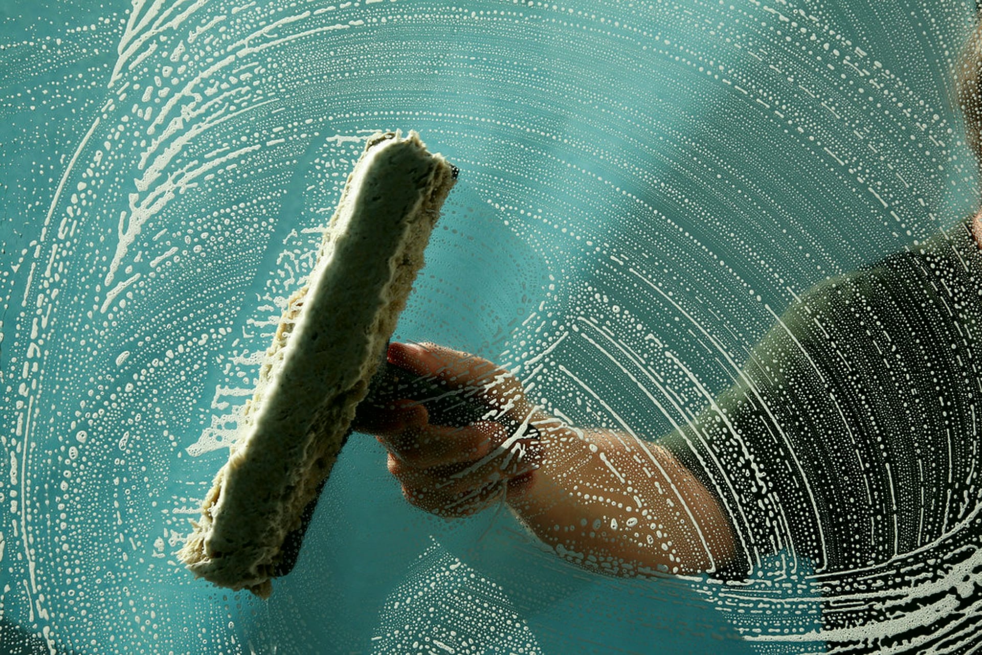 Soapy water being squeegeed from sparkling window glass